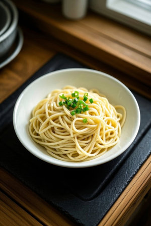 Wooden table bowl with noodles sprinkled with chopped green onionsの素材