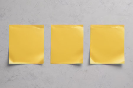 Close up of three yellow blank sticky notesの素材