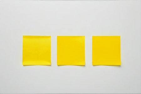 Three yellow sticky notes on a white backgroundの素材