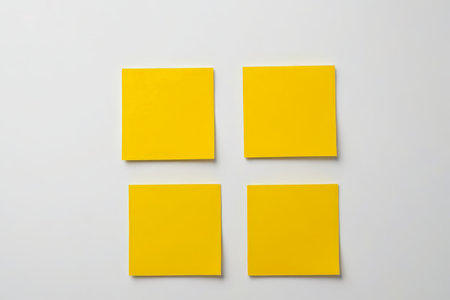 Four yellow sticky notes on a white backgroundの素材