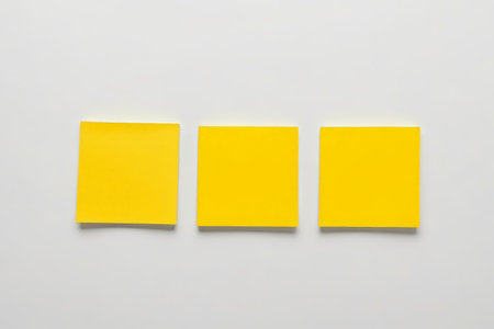 Three yellow sticky notes on a white backgroundの素材
