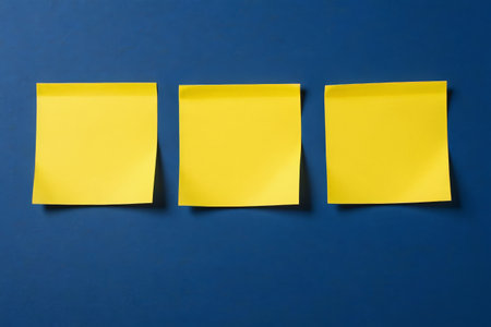 Three yellow sticky notes on a blue backgroundの素材
