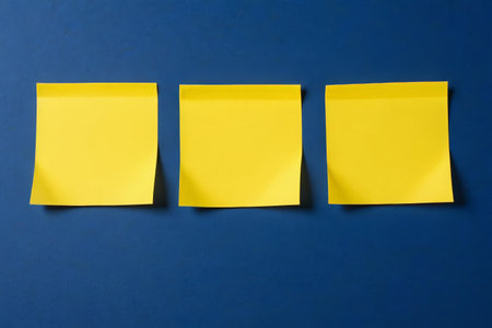 Three yellow sticky notes on a blue backgroundの素材