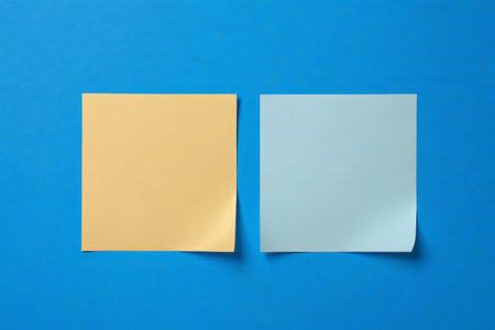 Two colored sticky notes on a blue backgroundの素材
