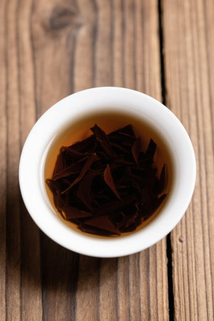 Close up of teacups and tea leaves on a wooden tableの素材