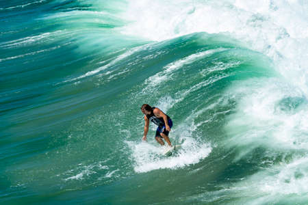 Huntington Beach, CA / USA - Sept 7, 2019: Surfer riding a beautiful ocean wave with lots of spray, sea foam and textures.のeditorial素材