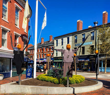 Portsmouth, NH / USA - Oct 16, 2018: Street light, the Athenaeum and autumn leaves at the corner of Congress Street and Pleasant Street in Market Square, with famous scarecrow pumpkins in autumn.のeditorial素材
