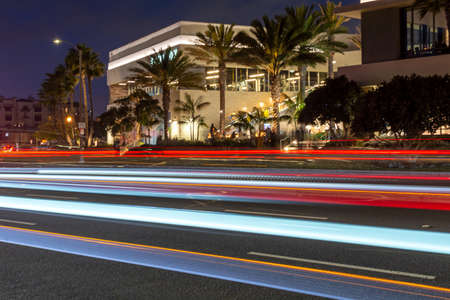Colorful light trails on a city road in Huntington Beach, California, in front of illuminated...