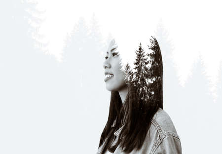 Duotone multiple exposure portrait of a beautiful, young woman and trees in the forest.