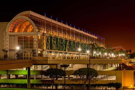 Long Beach, CA / USA - October 24, 2020: Night shot of the illuminated exterior of the Long Beach Convention and Entertainment Center, and red skies caused by light pollution.のeditorial素材