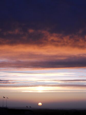 Cloudy sunset 5, a dramatic sunset with oranges on the edges of deep purple cloudsの写真素材