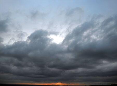cloudy sunset, a sunset with heavy cloudsの写真素材