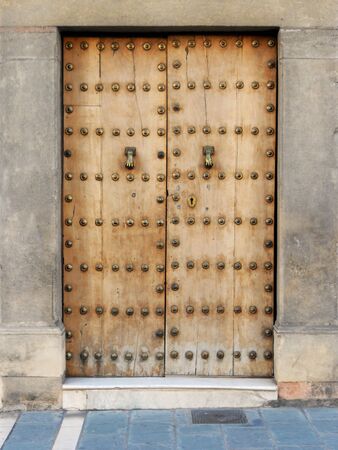 Ronda doorway 5, A door of golden wood with metal studs, set in cream stonework, Ronda  Spain の写真素材