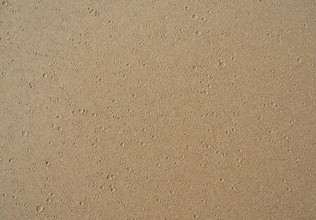 Sand with water drops, flat golden sand surface with small water drop shapesの写真素材