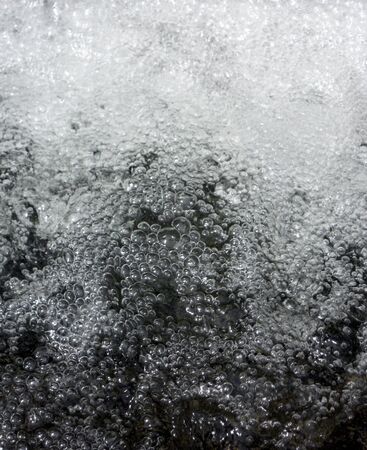 water bubbles texture, closeup of many small bubbles in water from a small artifical waterfallの写真素材