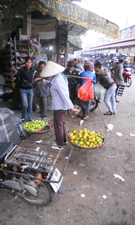 Hanoi market, market in Hanoi, with orange seller in traditional hatのeditorial素材