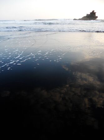 Black sand beach in evening lightの写真素材