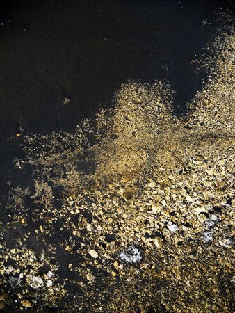 sand texture with black sand and gold colored sandの写真素材