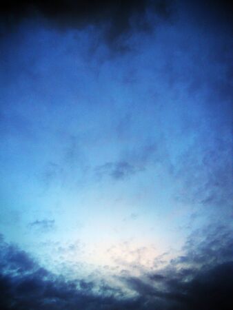 Small distant clouds in evening lightの写真素材