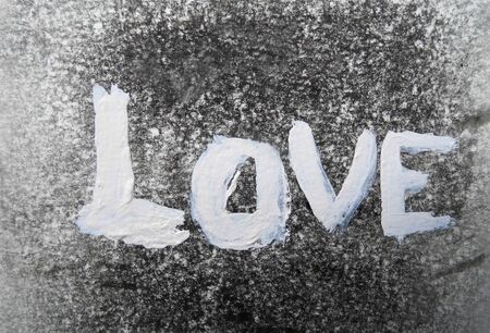 love painted, the word love hand-painted, artistic word love, lettering painted in white, on gray texture.の写真素材