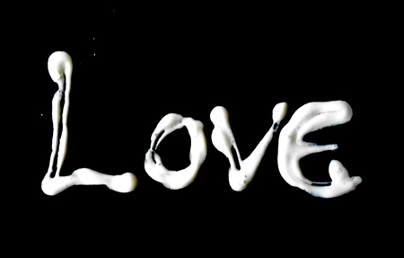 love painted, the word love hand-painted, artistic word love, white painted lettering with thick paint on black background.の写真素材