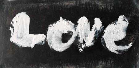 love painted, the word love hand-painted, artistic word love, rough brush lettering in wet white paint on dark gray painted texture.の写真素材