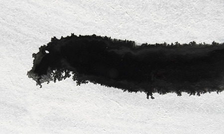 Marks and textures made by wet black and white water-based paints on pale background.の写真素材