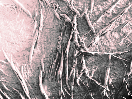 Closeup of painted organic texture made by glue crumpled tissue on painted board, oblique lighting, pink tints.の写真素材