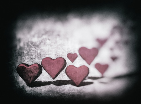 Aquatint style many 3D hearts, group of different sized pink heart shapes with shadows, on a grunge textured background.の写真素材
