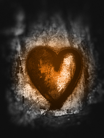 Grunge heart, rough painted heart shape on rough painted concrete texture, grays with orange tints, blur vignette.の写真素材