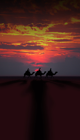 Three Kings Christmas card with the 3 wise men on camels on a simple desert landscape with shadows 3D image, with a real sunset, orange and red tints, tall.の写真素材