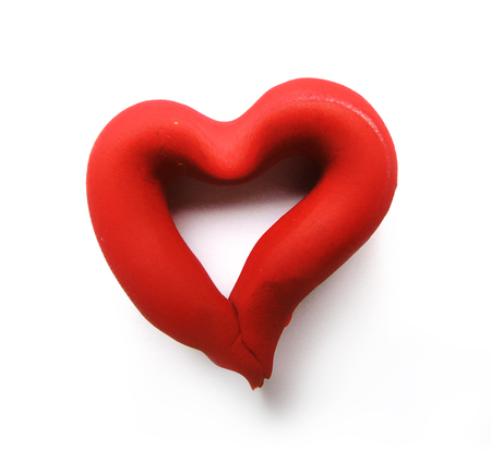 Curvy heart-shape outline made from red modeling-clay, with shadow, isolated on white background.の写真素材