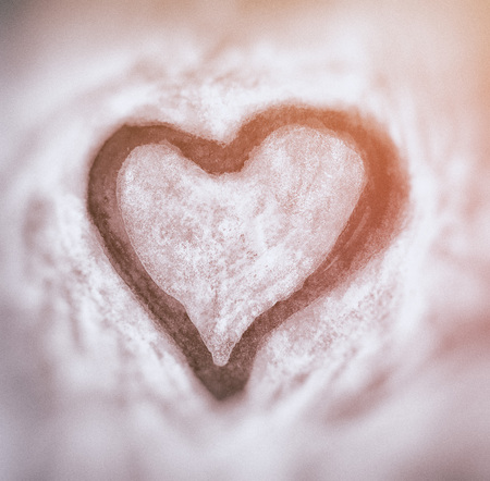 Rough painted heart-shape with dark outline on painted and drawn background. Blurred background.の写真素材