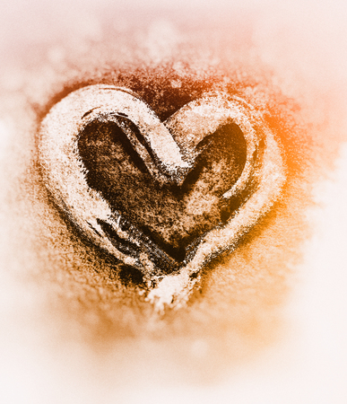 Rough painted brush-stroke heart-shape, on rough watercolor paper, with blurred background.の写真素材