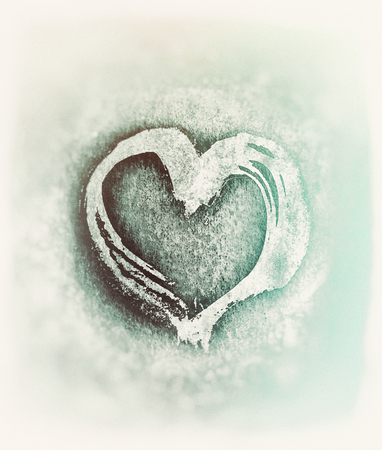 Rough painted heart shape on a rough surface. Pale blurred background.の写真素材