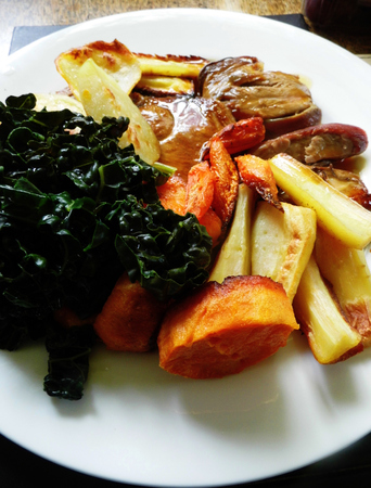 Roast lamb with vegetables on a plate on a table.の写真素材
