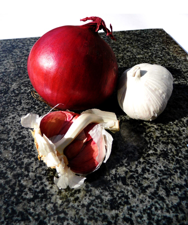 Red onion and garlic on a chopping board.の写真素材