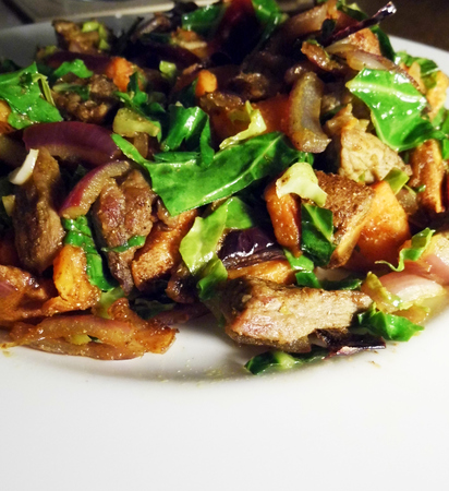 Stir fried meat and vegetables on a white plate on a table, closeup.の写真素材