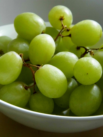 White grapes in a small ceramic bowl, with water drops.の写真素材