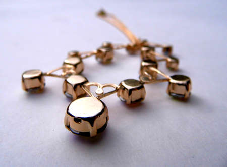 Gold bracelet closeup, on a flat surface.の写真素材