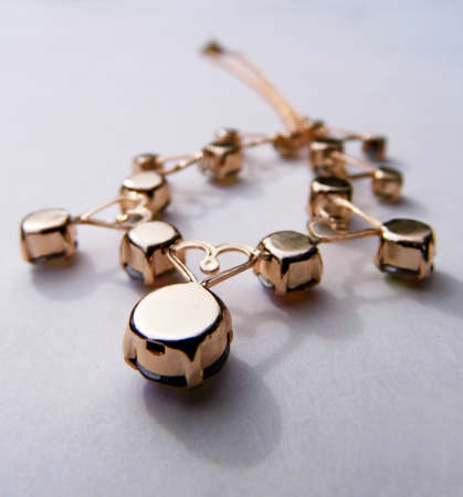 Gold bracelet closeup, on a flat surface.の写真素材