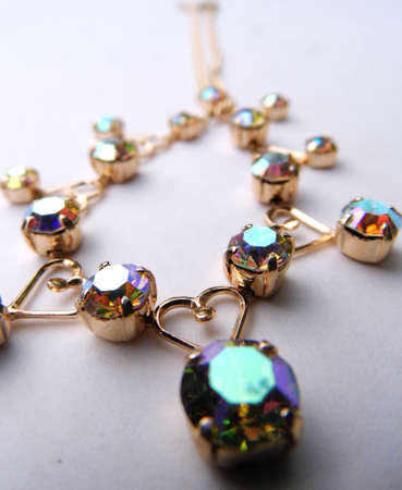 Gold bracelet with colored glass closeup, on a flat surface.の写真素材