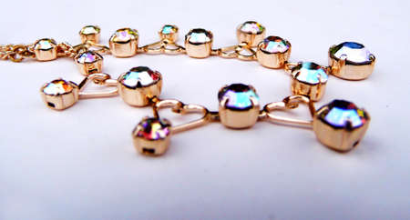 Gold bracelet with colored glass closeup, on a flat surface.の写真素材