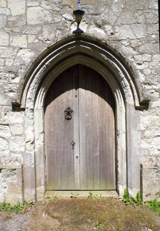 An old church doorway in the sun, with wood and pale stone, with a pointed arch.の写真素材