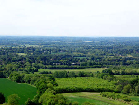 British summer landscape, from a hill, with fields, farms and forests, Surrey, UK.の写真素材