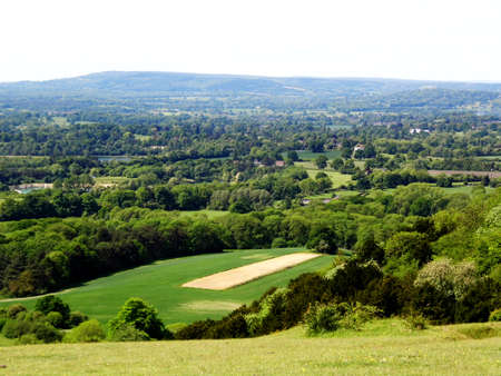 British summer landscape, from a hill, with fields, farms and forests, Surrey, UK.の写真素材