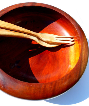 A wooden salad bowl with salad tongs.の写真素材