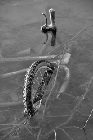 vertical bike sunk into the riverの写真素材