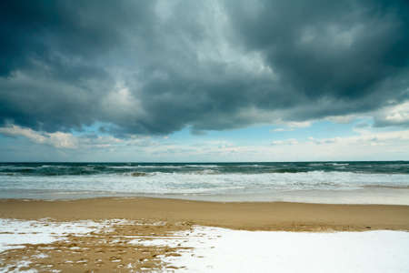 Black sea beach in the winter, with snow on the sandの写真素材