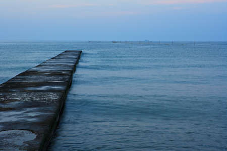 Old quay in a morning blue sea waterの写真素材